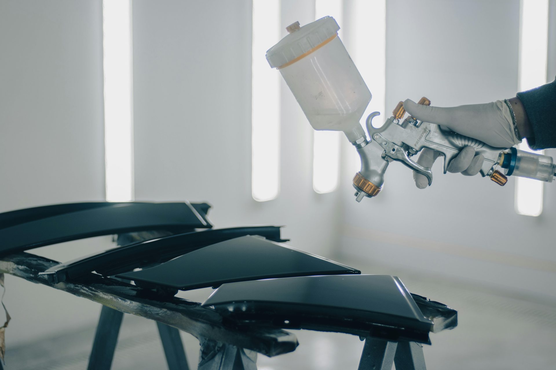 Nahaufnahme von Autoteilen, die in einer Autowerkstatt lackiert werden.