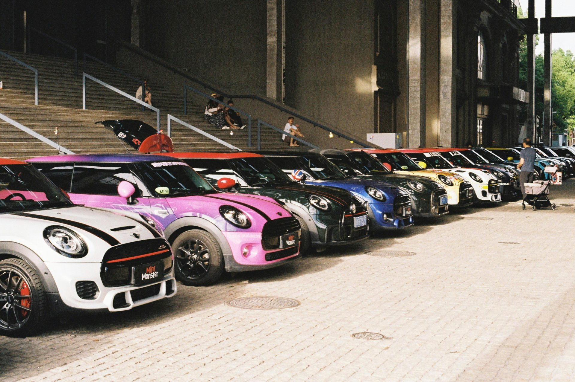 Eine Reihe bunter Mini Cooper-Autos parkte vor dem Gebäude